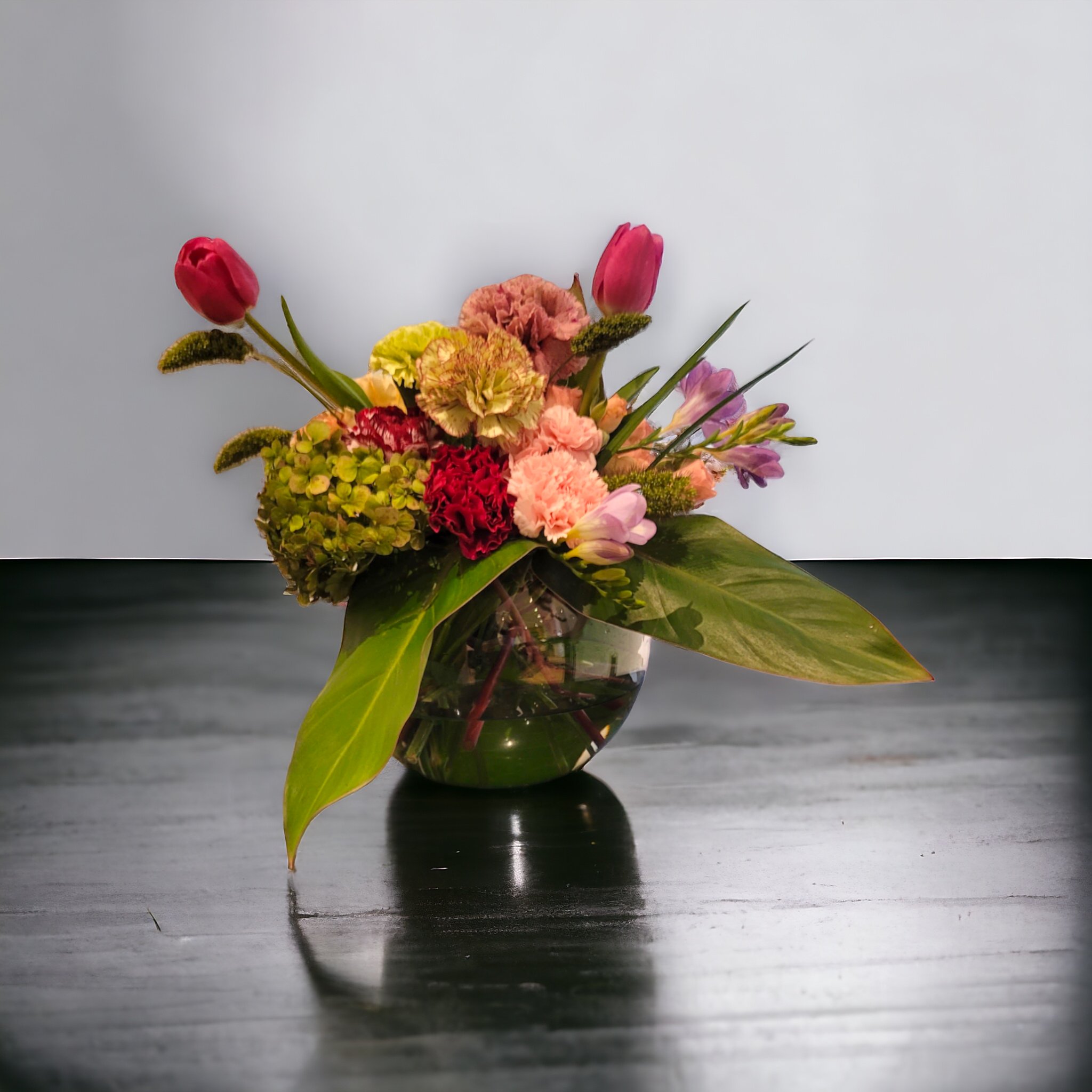 Arranjo de tulipas, cravos e folhagens produzido pelo Studio das Flores